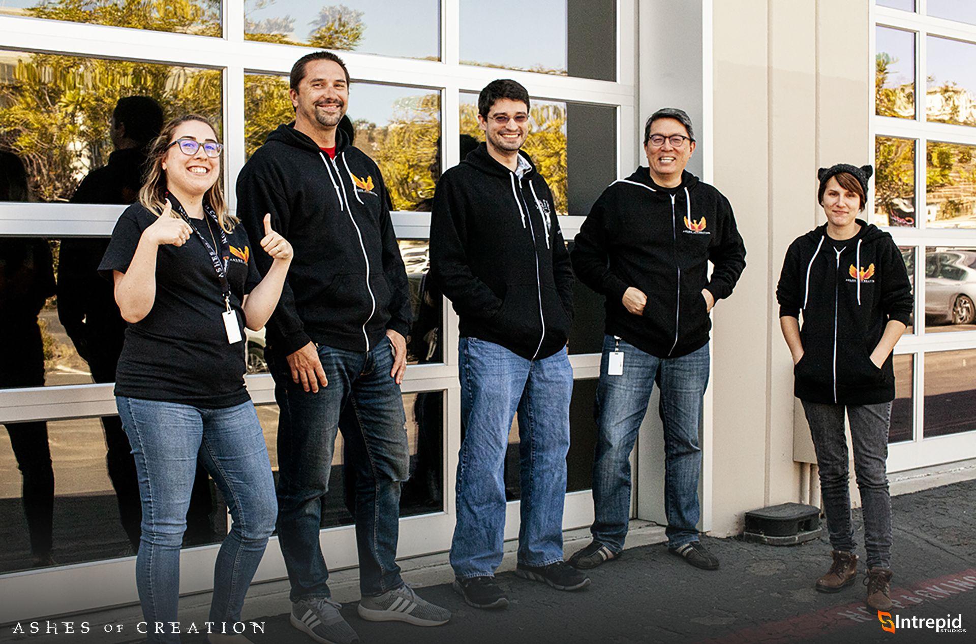 Five new Intrepid Studios hires of both male & female standing outside of a glass garage door